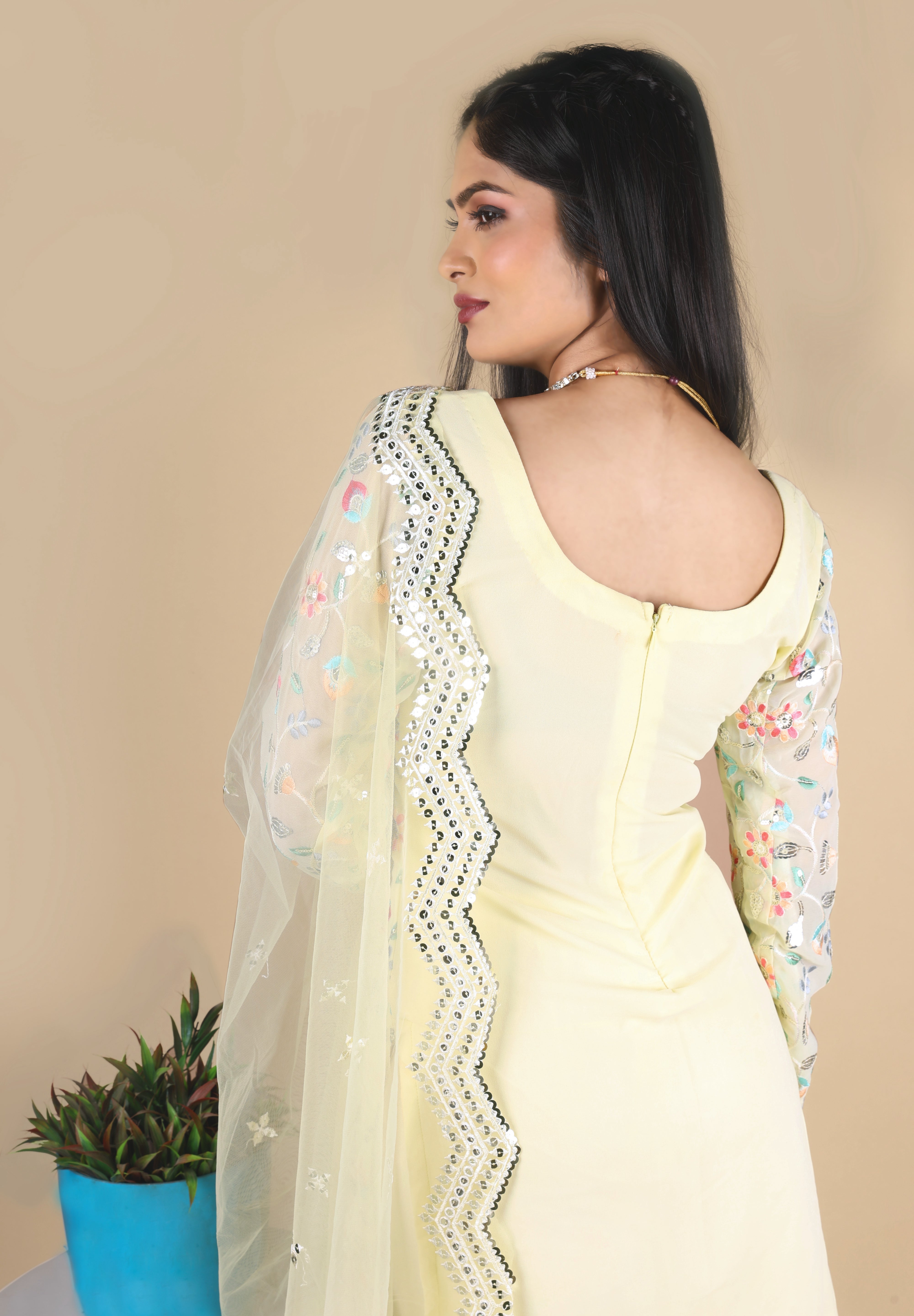 Light yellow sharara suit with embroidery work. It has a plain sharara and net dupatta. 