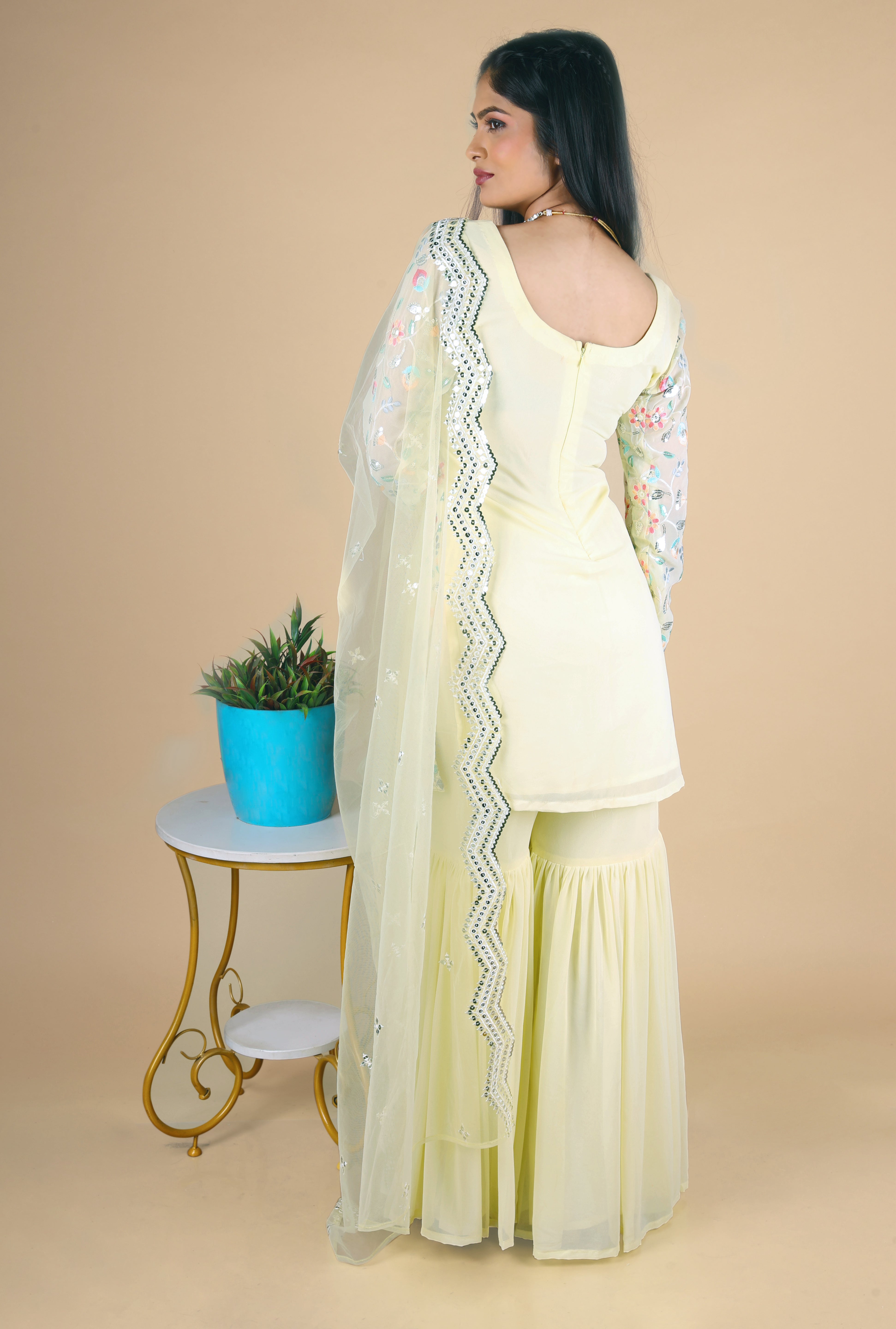 Light yellow sharara suit with embroidery work. It has a plain sharara and net dupatta. 