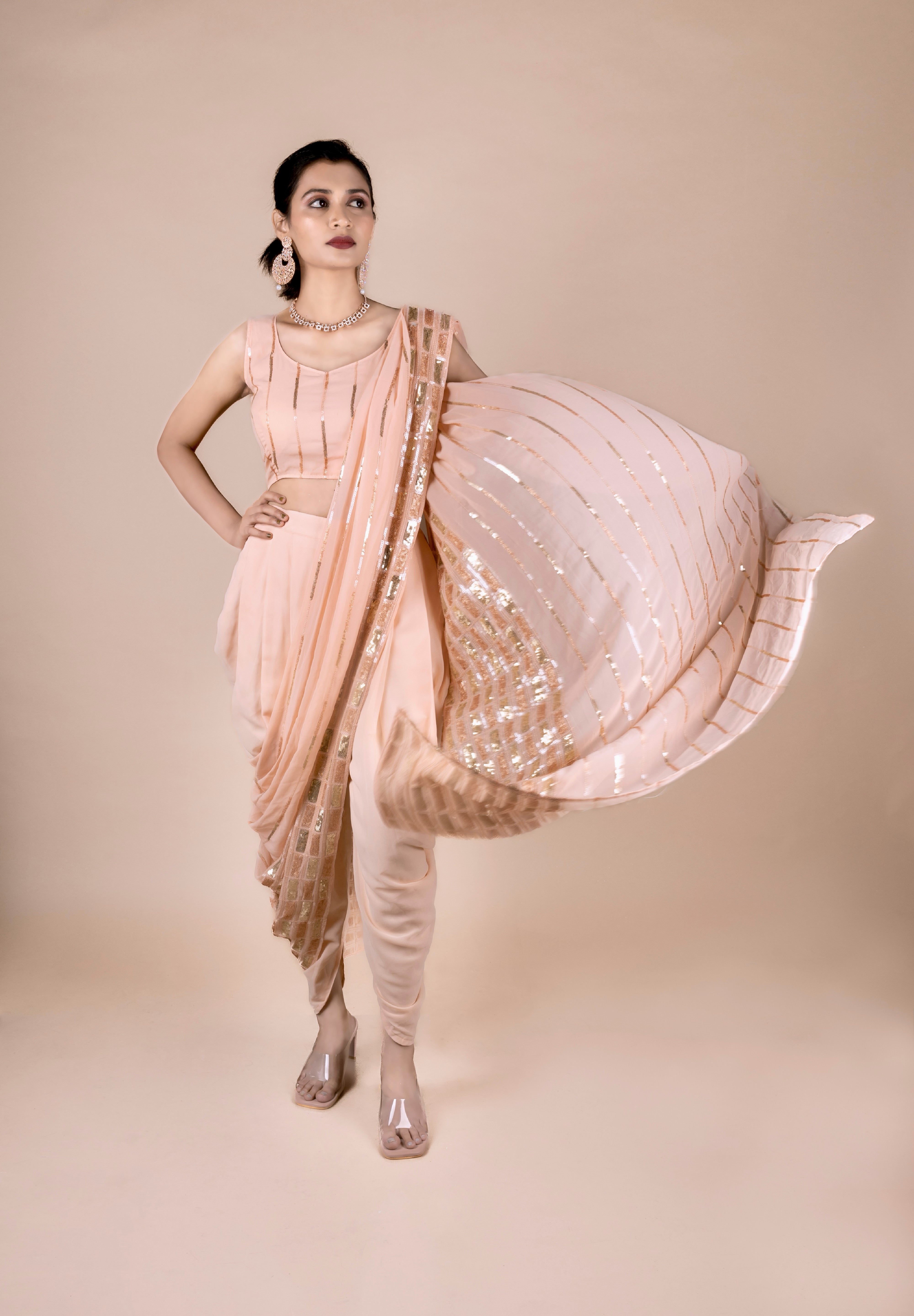 Peach dhoti saree in indowestern style. It has beautiful sequins embroidery work. 