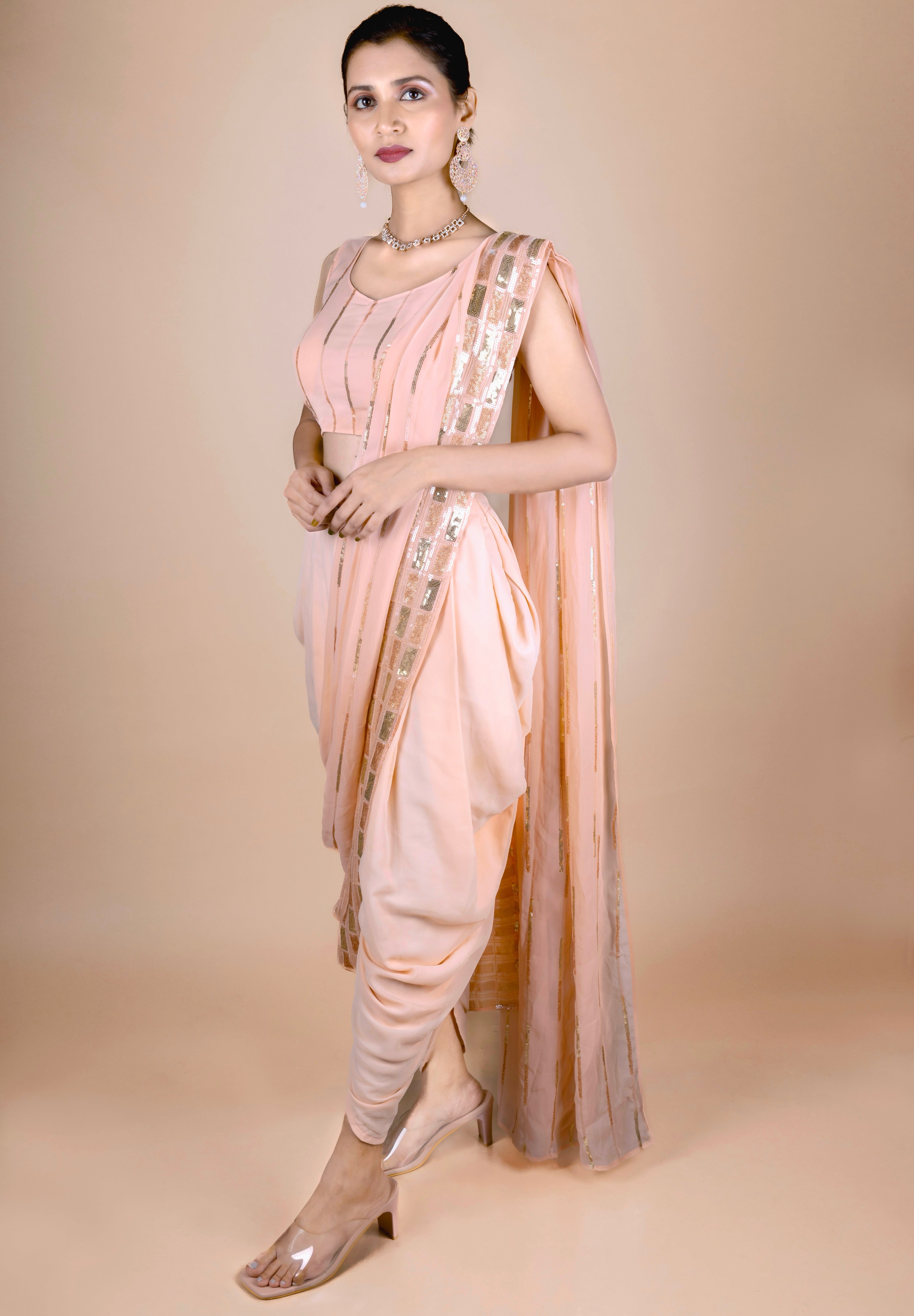 Peach dhoti saree in indowestern style. It has beautiful sequins embroidery work.