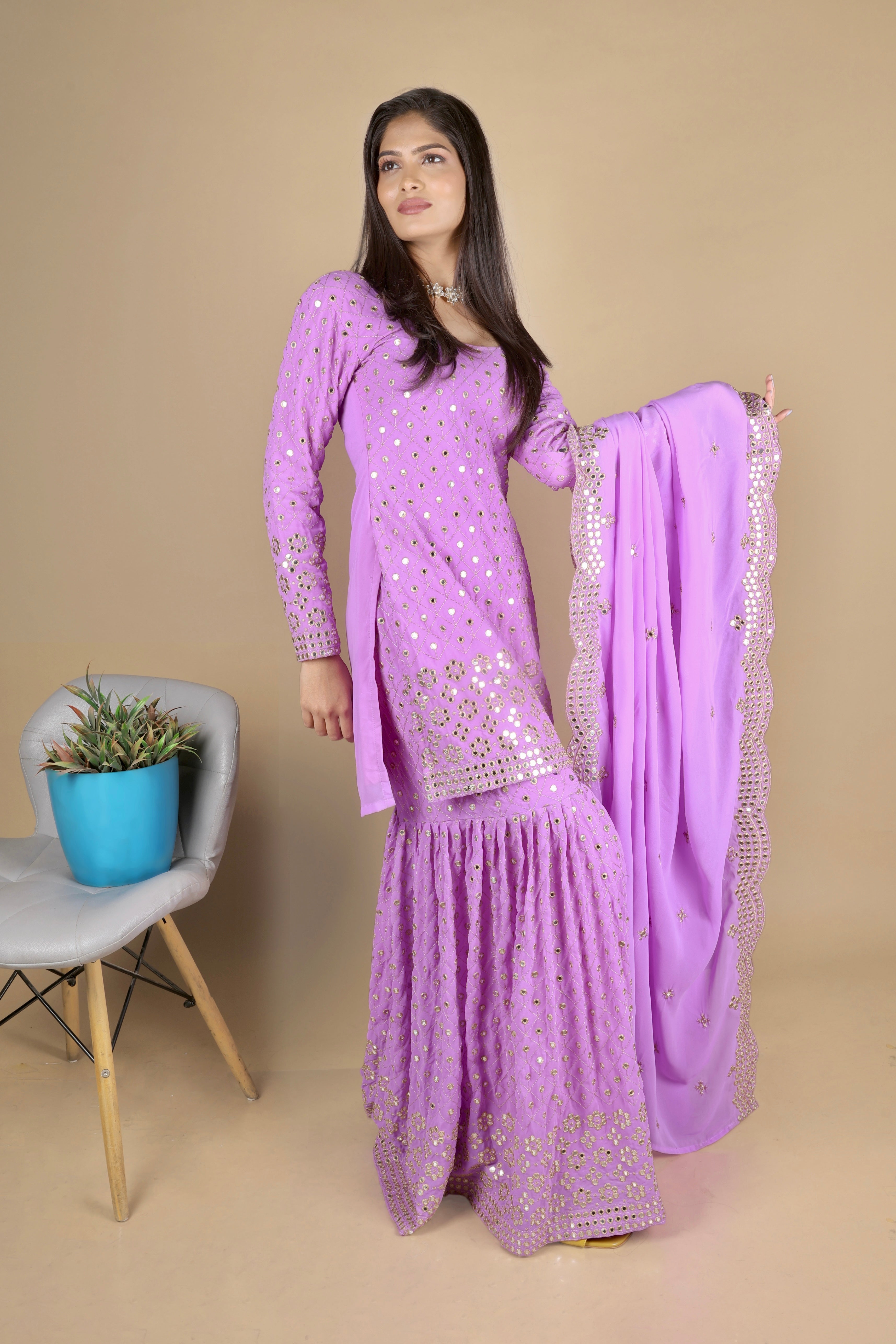 Purple sharara suit with full sleeves and zari embroidery work. The sharara has full flare. The dupatta is long and has the same work as the suit. 