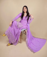 Purple sharara suit with full sleeves and zari embroidery work. The sharara has full flare. The dupatta is long and has the same work as the suit. 