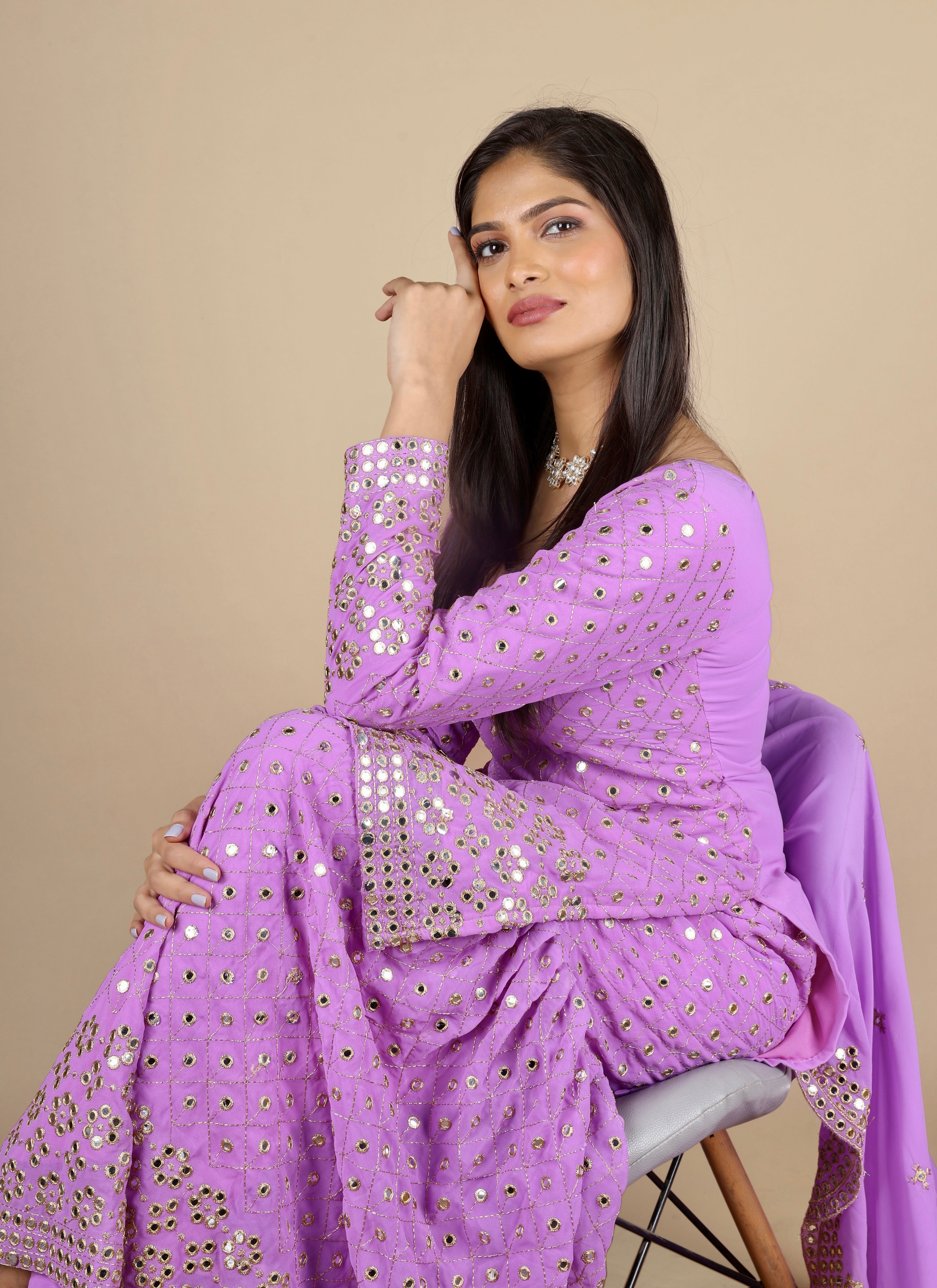 Purple sharara suit with full sleeves and zari embroidery work. The sharara has full flare. The dupatta is long and has the same work as the suit. 